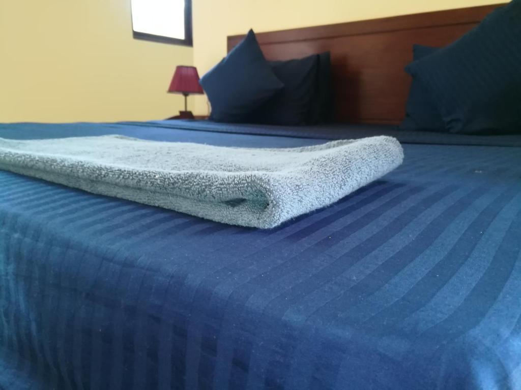 een blauw bed met een deken erop bij Lake Bliss in Dambulla