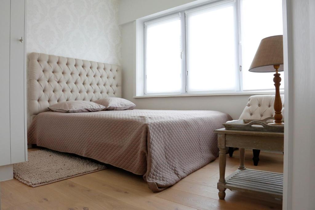 een slaapkamer met een bed en een tafel met een lamp bij ZEN op Vakantie - Zen aan Zee Duinbergen in Knokke-Heist