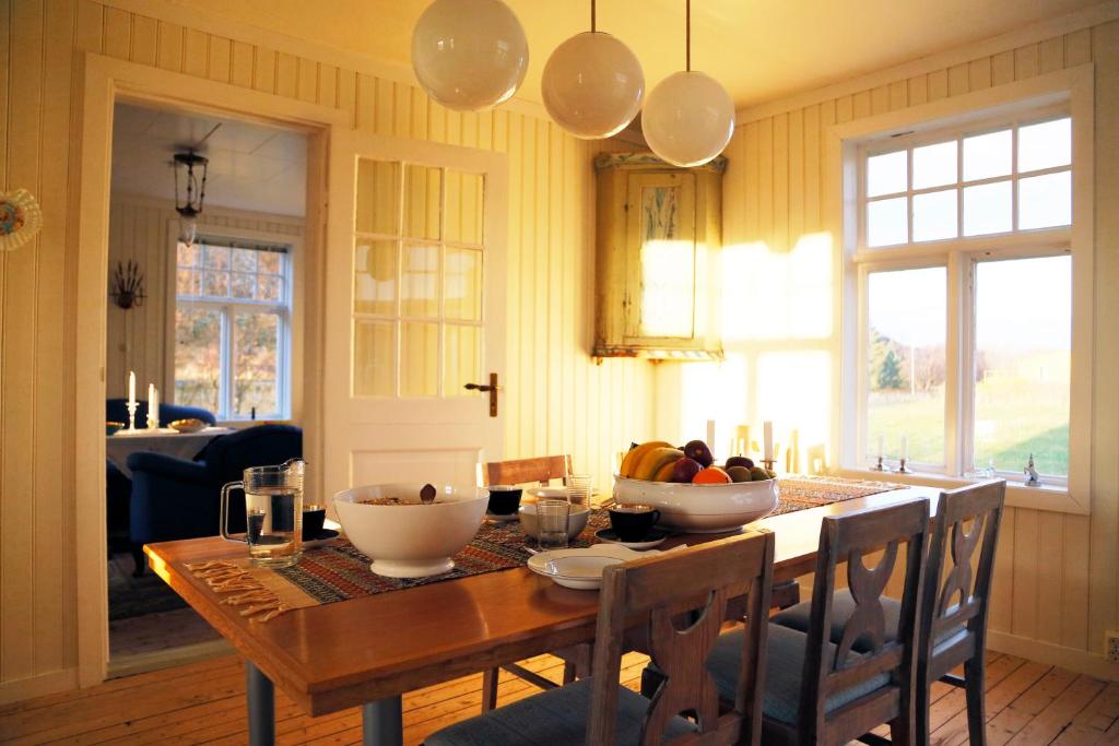 a dining room table with a bowl of fruit on it at Villa Lofoten - The Farmhouse in Kvalnes