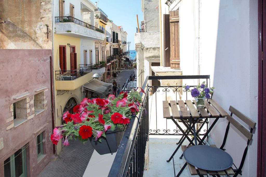 a balcony with flowers and tables and chairs on a building at Talos in Chania