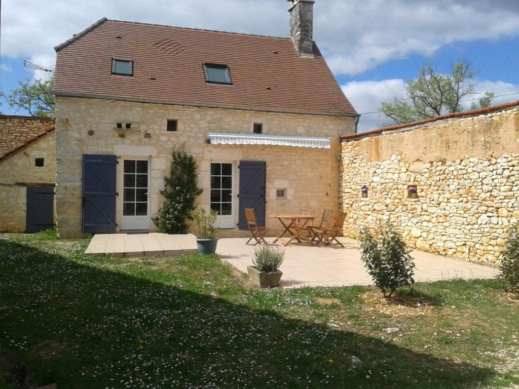 a stone building with a picnic table in front of it at Les Gîtes du Villajou in Lachapelle-Auzac
