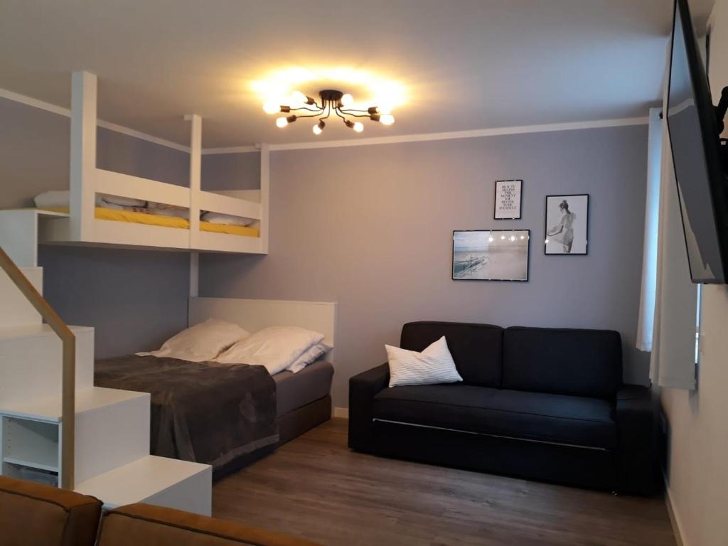 a bedroom with a bed and a couch and bunk beds at Petit Bagage 2019 Neueröffnung in Sankt Augustin