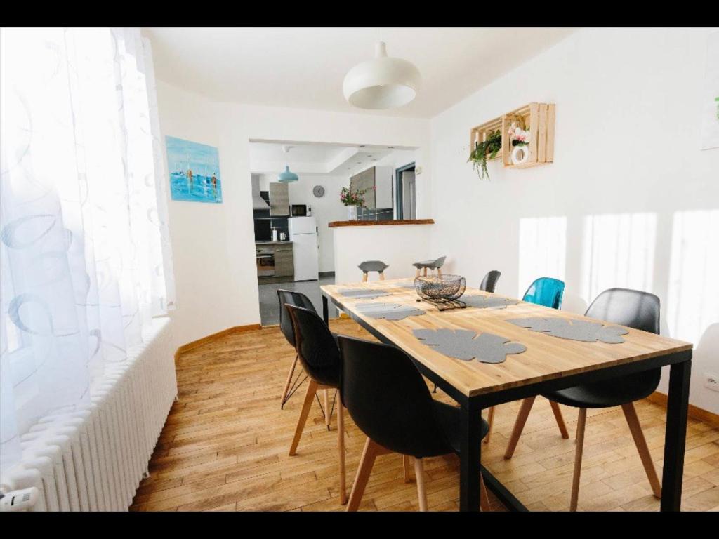 - une salle à manger avec une table et des chaises en bois dans l'établissement charmante maison lumineuse et confortable, à Le Poinçonnet