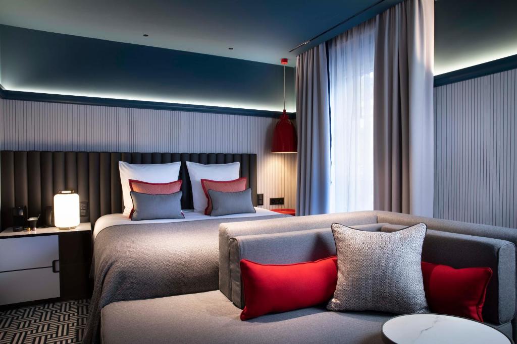 a hotel room with two beds and a couch at Hotel D Geneva in Geneva