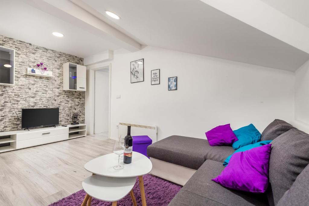 a living room with a couch and a tv at Bella Central apartment in Rijeka