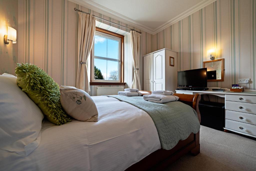 A bed or beds in a room at The Rowan Tree Country Hotel