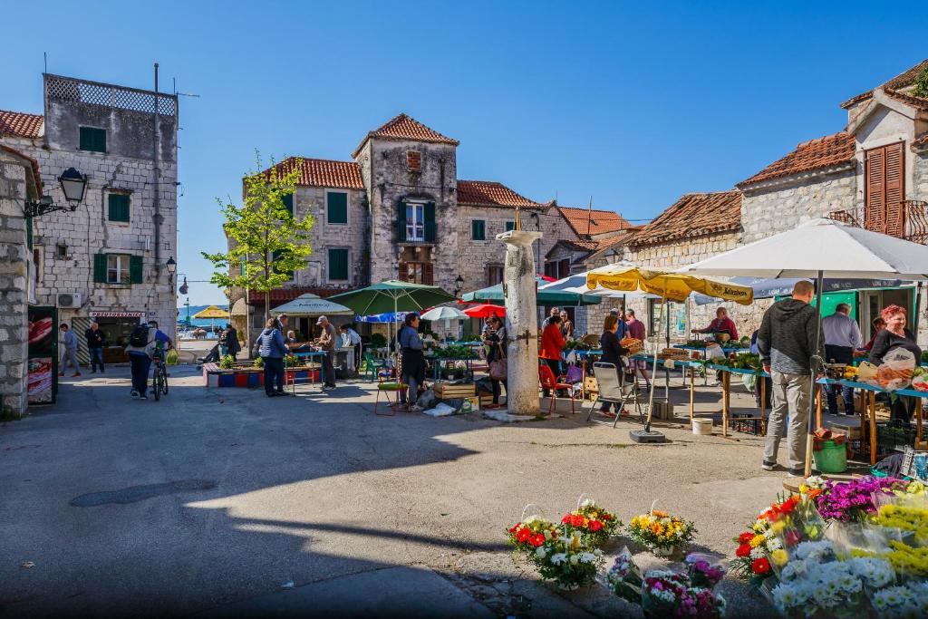 a group of people standing at an outdoor market at Central Apartment Castle Cippico in Kaštela