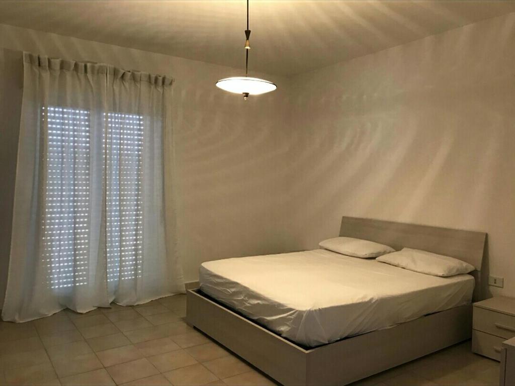 a bedroom with a bed and a large window at Grattacielo alla Stazione in Sannicandro Garganico