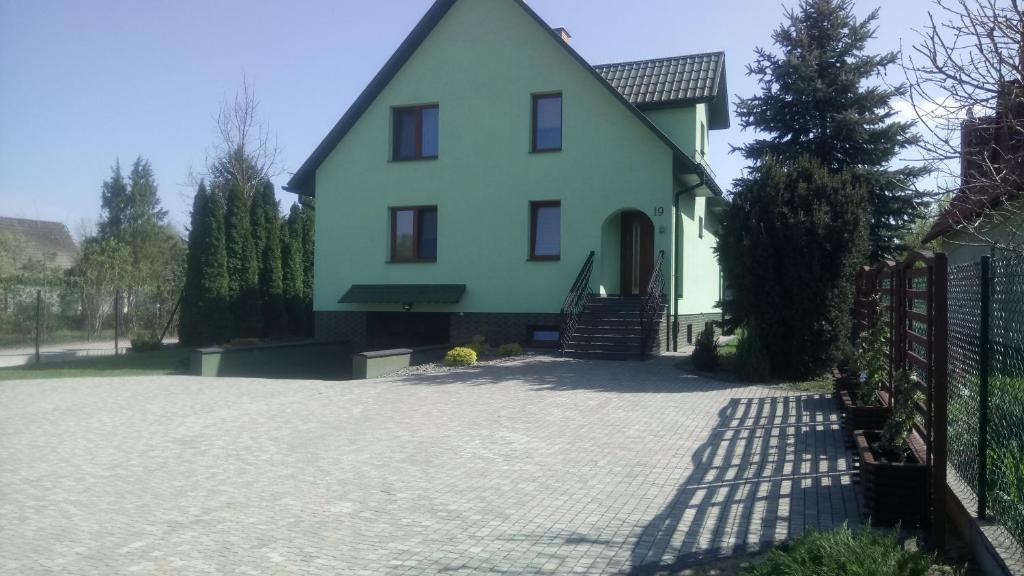 una casa blanca con una entrada delante de ella en Apartament nad zalewem przy plaży, en Jedlnia-Letnisko