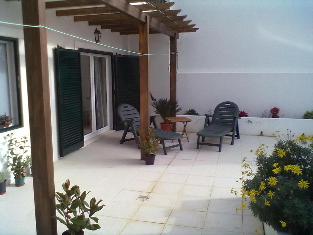 um pátio com cadeiras e uma mesa e algumas plantas em Ericeira - Apartment with Patio - Horizonte Mar na Ericeira