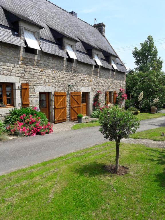un bâtiment avec un arbre devant lui dans l'établissement La grange, à Kervignac