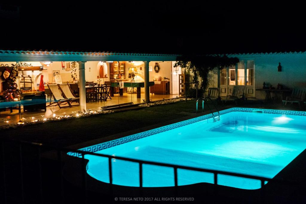 uma piscina à noite com uma casa ao fundo em Horta da Fonte em Alburitel
