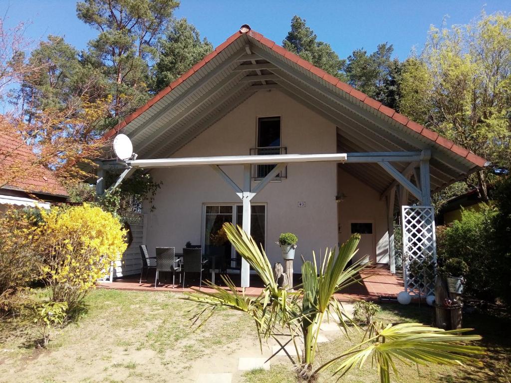 uma pequena casa branca com um alpendre em Ferienhaus am Fleesensee em Silz