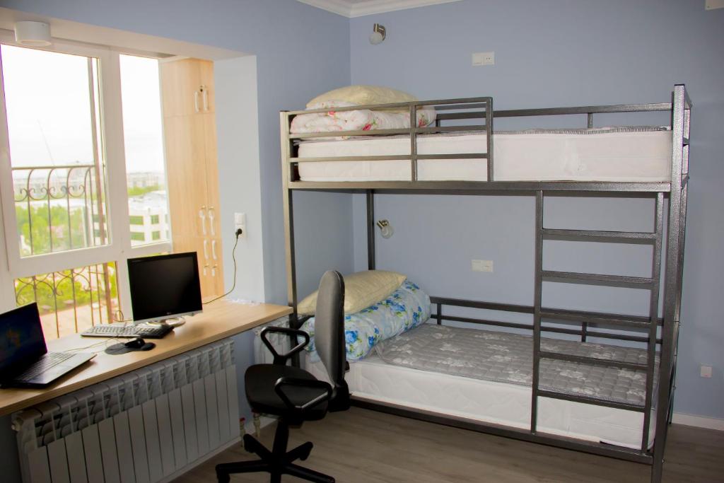 a bedroom with bunk beds with a desk and a computer at Hostel - Guest House Meyman in Almaty