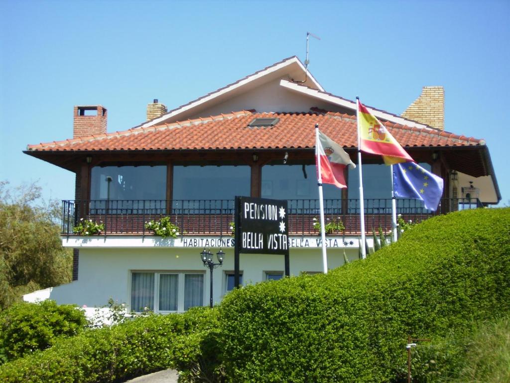 a building with flags in front of it at Pensión Bella Vista in Cóbreces