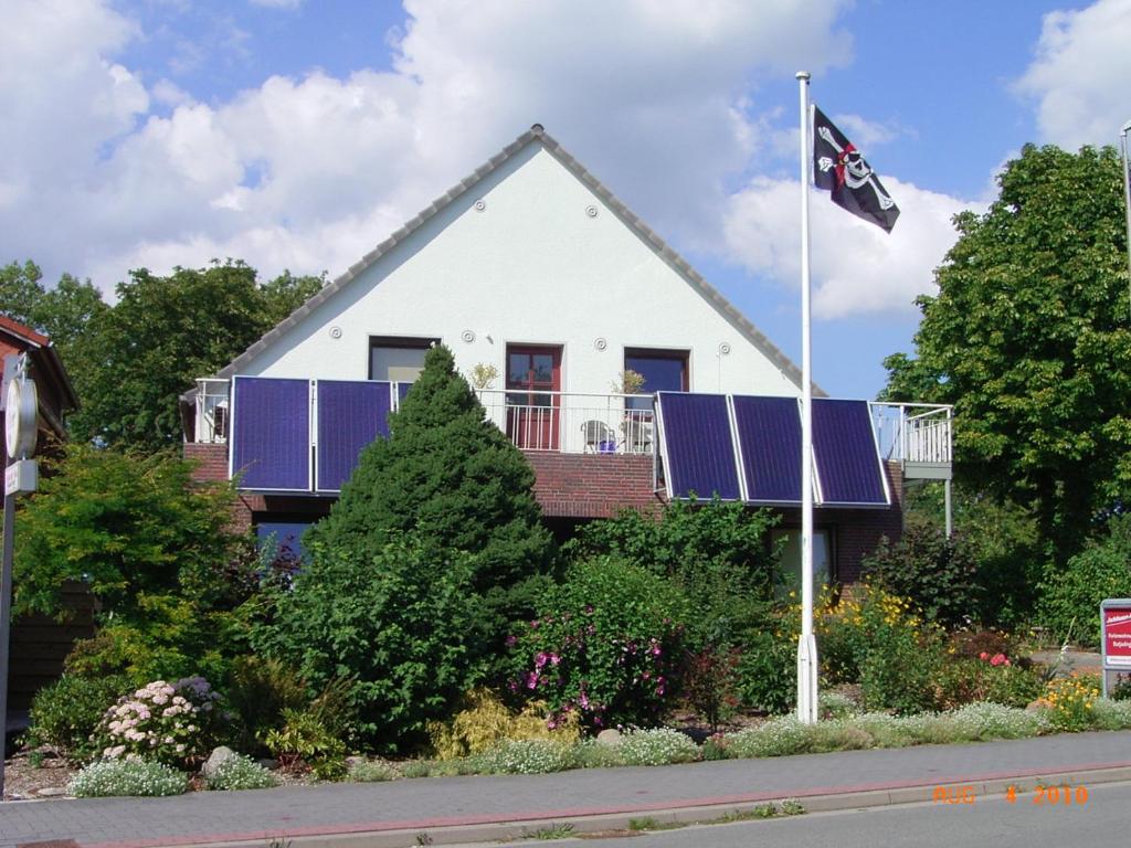 a house with solar panels on it with a flag at Ferienhaus Herter in Butjadingen