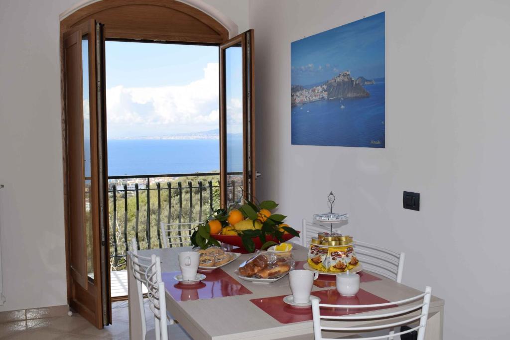 ein Esszimmer mit einem Tisch und Meerblick in der Unterkunft ACHILLE HOME B&B SORRENTO in Sorrent