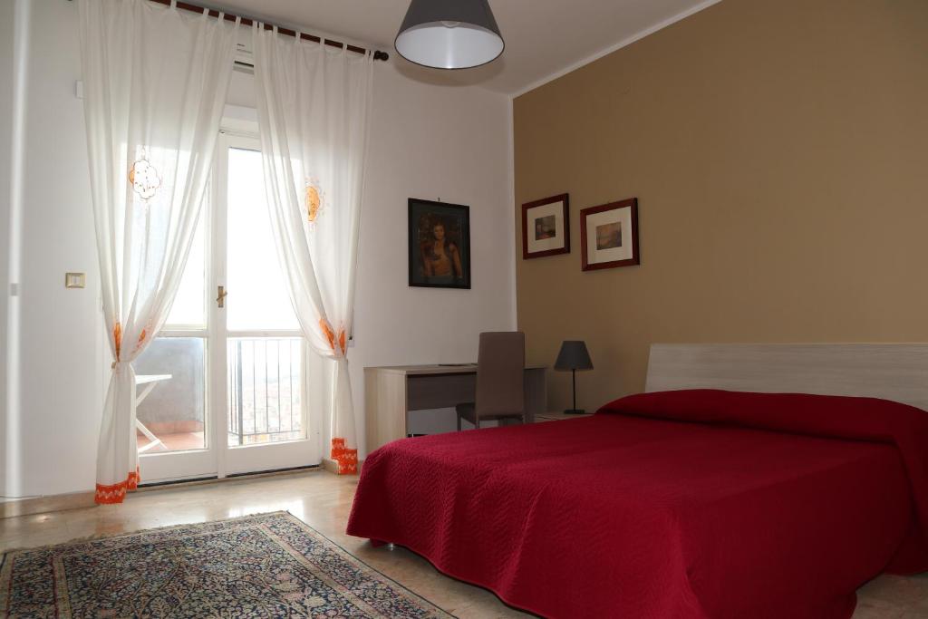 1 dormitorio con cama roja y ventana en Casa Antonellina en Nápoles