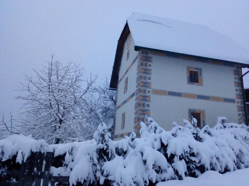 a building covered in snow next to some trees at Turmhaus am Perschlhof in Murau