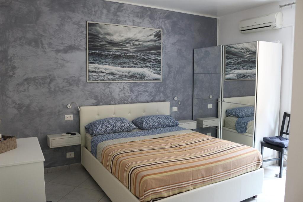 1 dormitorio con 1 cama y una pintura en la pared en B&B Del Corso, en Cefalú