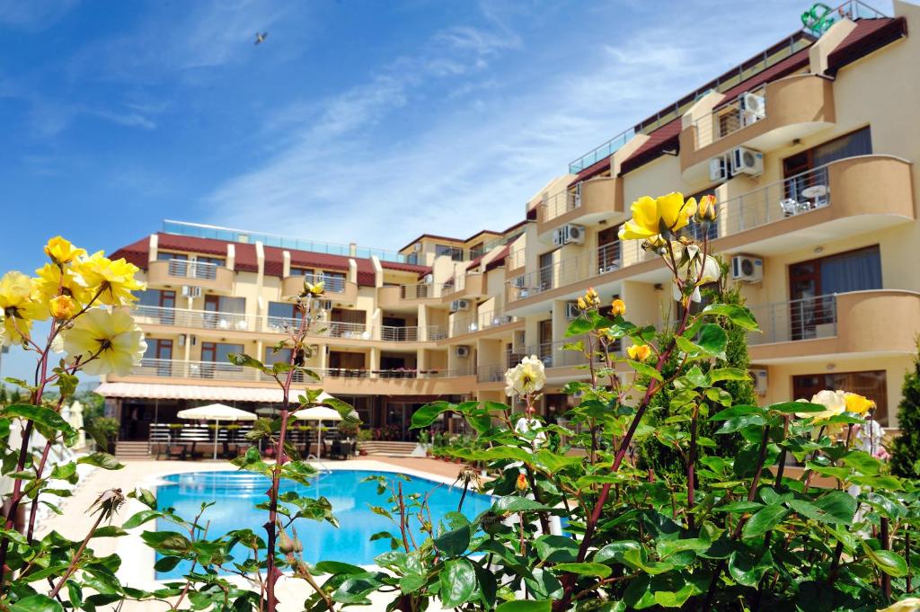 a hotel with a swimming pool in front of a building at Hotel Iris in Nesebar