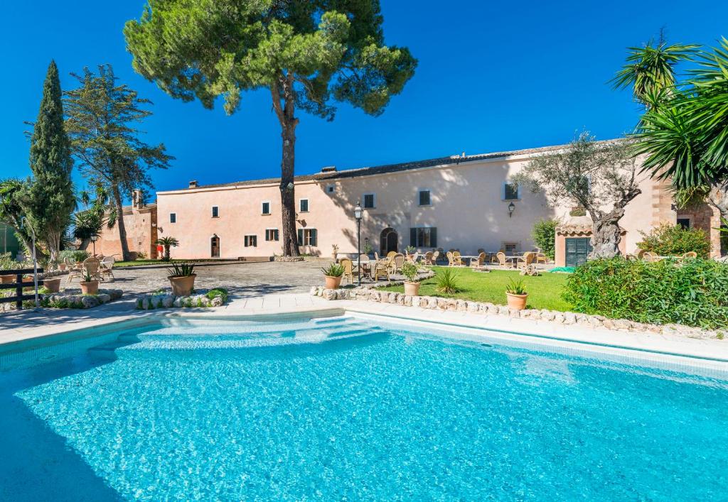 a swimming pool in front of a house at Petit Hotel Rural Son Jordá in Sencelles