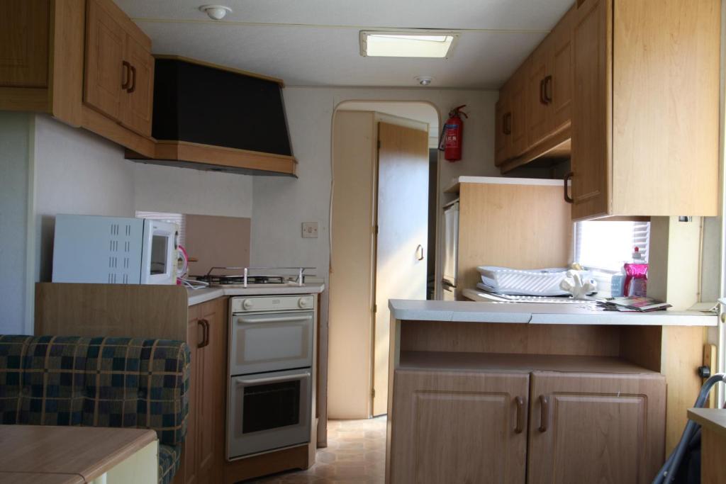 a kitchen with wooden cabinets and a white stove top oven at lathuillere in La Motte-Saint-Jean