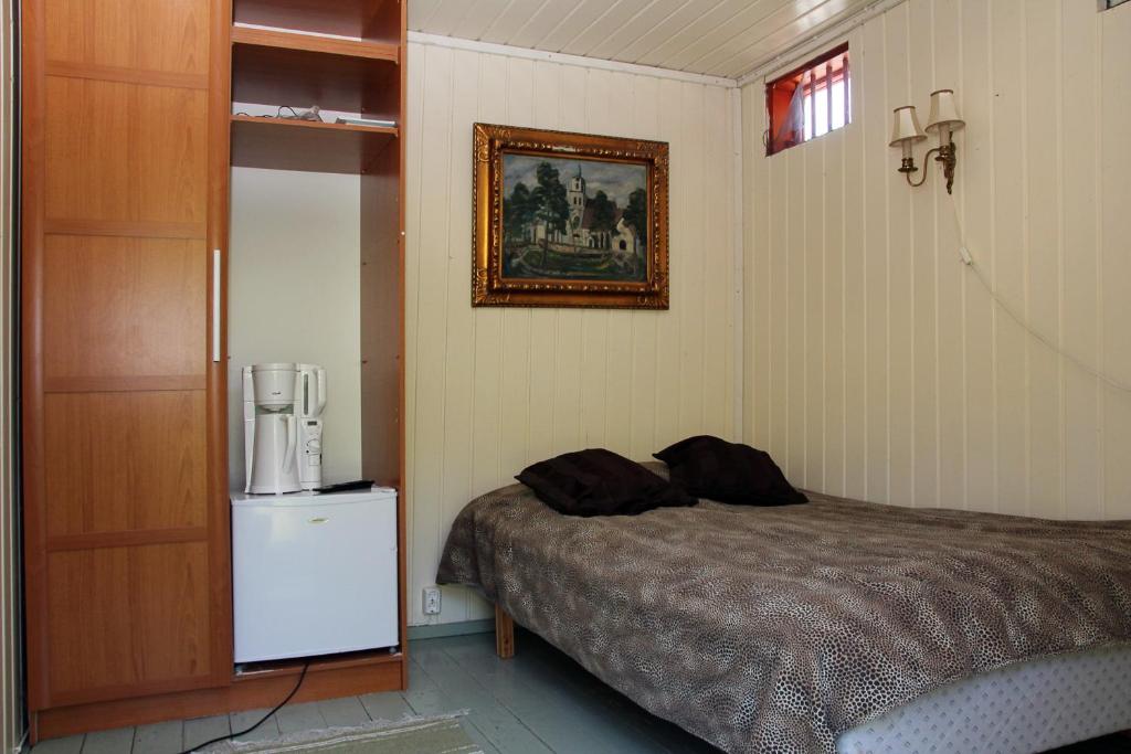sypialnia z łóżkiem i zdjęciem na ścianie w obiekcie Putka , Jailhouse w mieście Salo