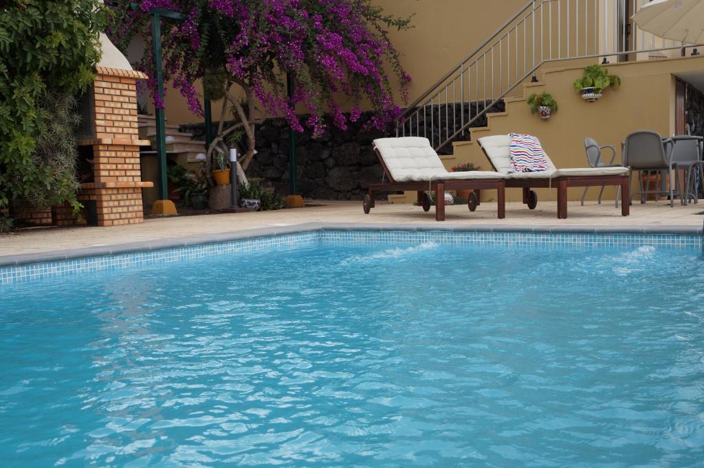 a swimming pool with two chairs and a bench next to it at Casa Aloe in El Paso