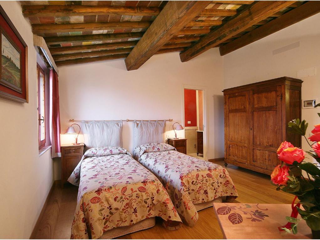 a bedroom with a bed and a wooden ceiling at Casacenti B&B in Siena