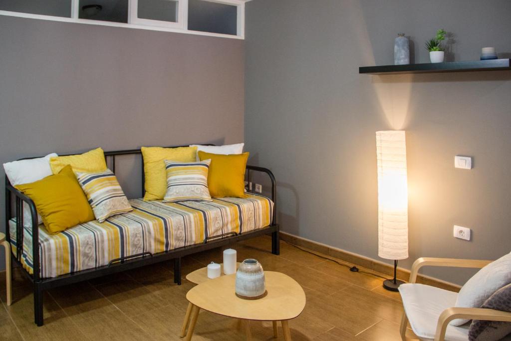sala de estar con sofá y almohadas amarillas en Acogedor apartamento con vista al mar, en Tacoronte