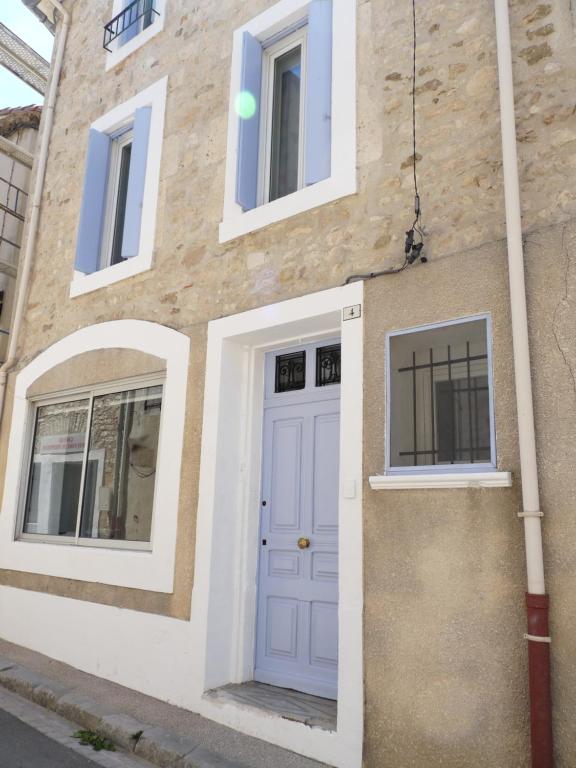 dom z niebieskimi drzwiami i oknami w obiekcie appartement de la callade w mieście Peyriac-de-Mer