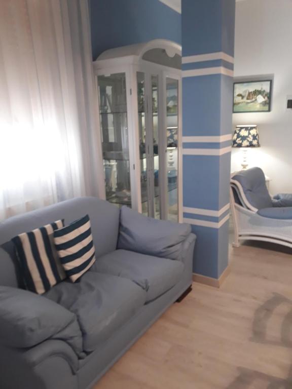sala de estar con sofá gris y paredes azules en Loving Salento, en Porto Cesareo