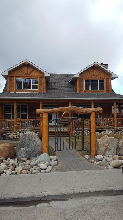 ein Holzhaus mit einem Tor davor in der Unterkunft Roche Bonhomme Rustic Suite in Jasper