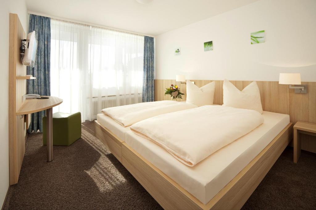 
a hotel room with two beds and a large window at Gasthof Lerner in Freising
