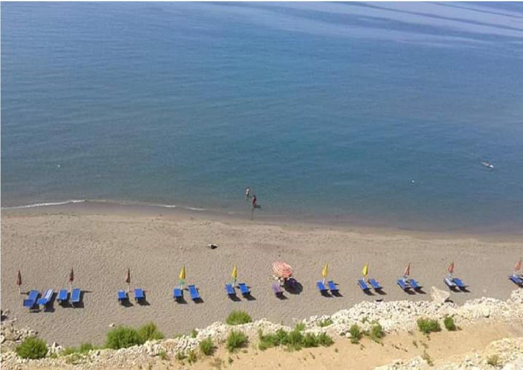 a group of chairs and umbrellas on a beach at Romantika in Shëngjin