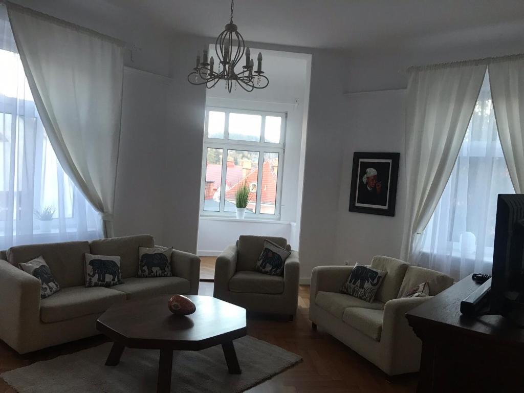 a living room with two couches and a table at Nokturn Apartament in Duszniki Zdrój