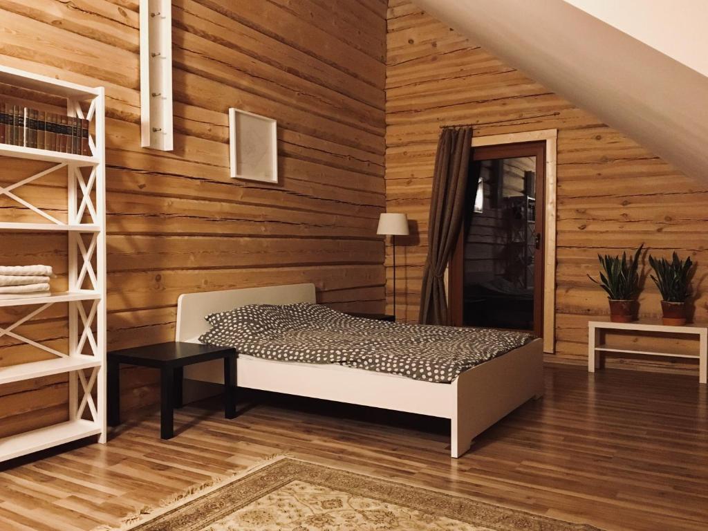 1 dormitorio con 1 cama en una pared de madera en Room in a Scandinavian Style House en Vilna