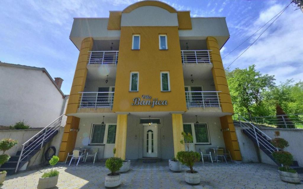 a yellow building with a sign that reads the burpheus at Apartments Banjica in Soko Banja