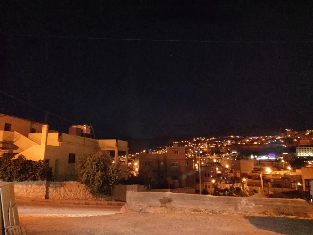 a view of a city at night with lights at Petra Heritage House in Wadi Musa