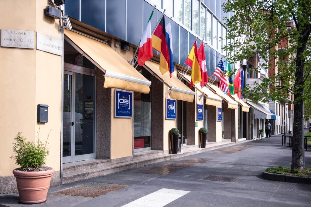 una strada con bandiere di fronte a un edificio di Hotel Oro Blu a Milano