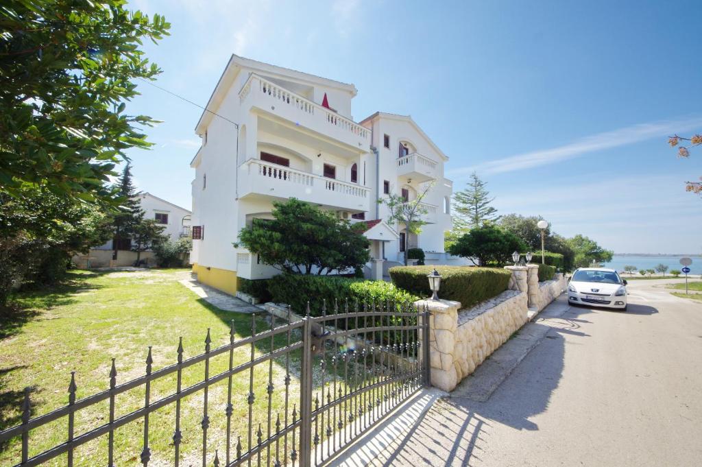 uma villa com um carro estacionado em frente em Apartments Beach em Vrsi