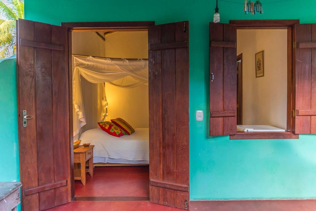 an open door to a bedroom with a bed at Suíte Charmosinha in Caraíva