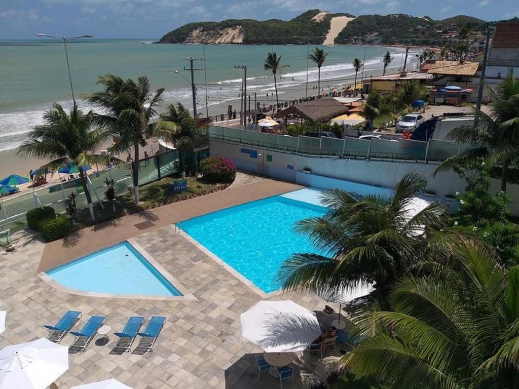 een luchtzicht op een zwembad en het strand bij Sonia Flats Natal - No Apart Hotel Ponta Negra Beach in Natal