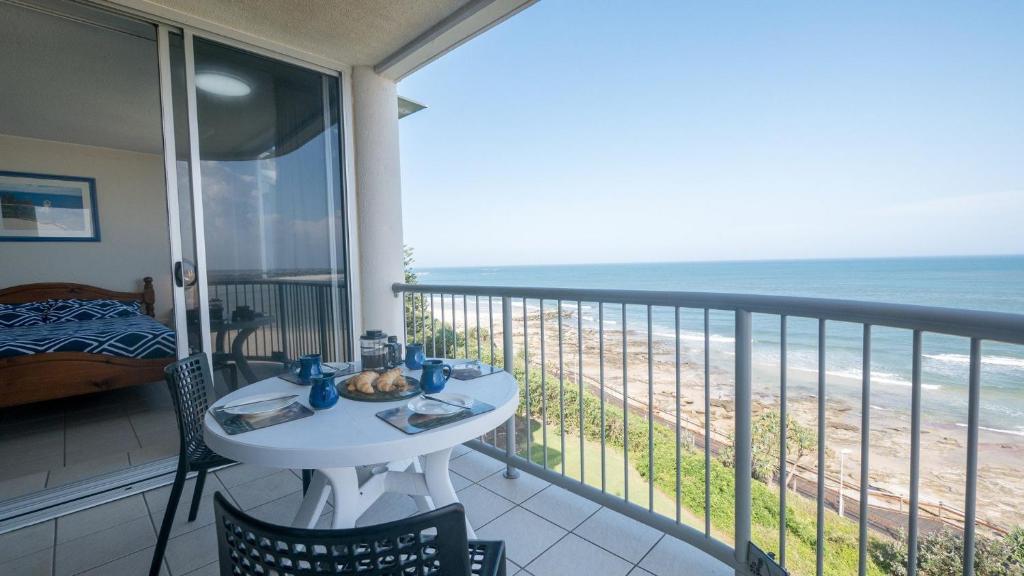 balcón con mesa y vistas a la playa en Monterey Lodge Unit 16 27 Warne Terrace Kings Beach en Caloundra