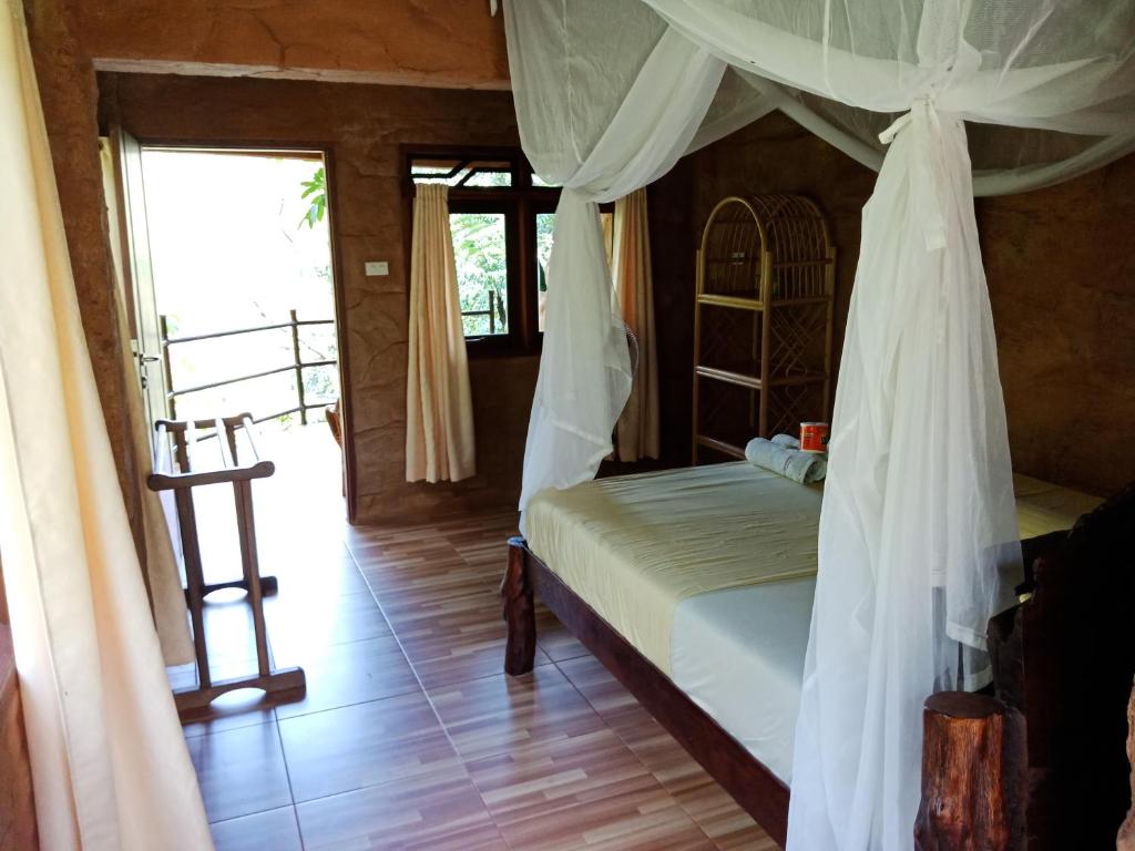 a bedroom with a bed and a ladder in it at On The Rocks Bungalows, Restaurant and Jungle Trekking Tours in Bukit Lawang