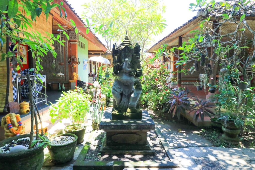 a statue in the middle of a garden at Mertha Jati Hotel in Kuta