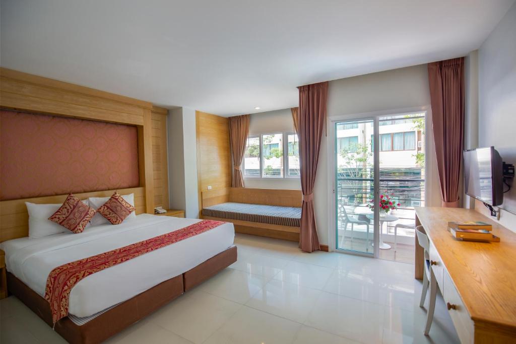 a hotel room with a bed and a balcony at Sungthong Kamala Beach Resort in Kamala Beach