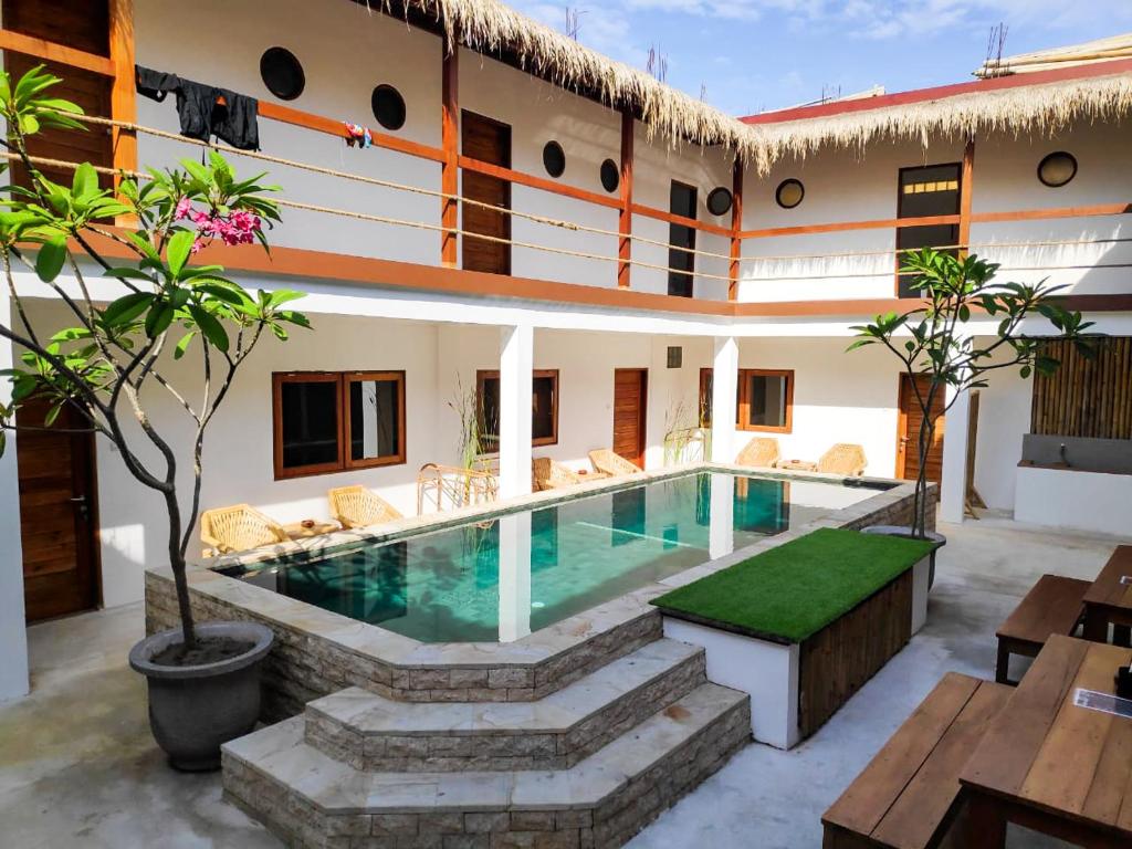 a villa with a swimming pool in a courtyard at Gili Pirates in Gili Trawangan