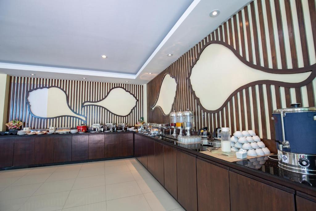 a restaurant with a bar with a striped wall at Sungthong Kamala Beach Resort in Kamala Beach